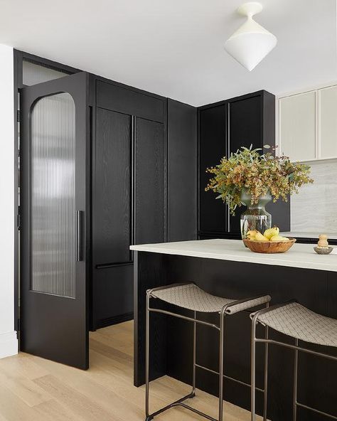 A hidden walk-in pantry is concealed behind a black door finished with a rippled glass panel. Walk In Pantry Design, Kitchen Door Designs, White French Doors, Wooden Pantry, Collective Studio, Steel French Doors, Glass Pantry Door, Light Gray Cabinets, Grey Kitchen Island