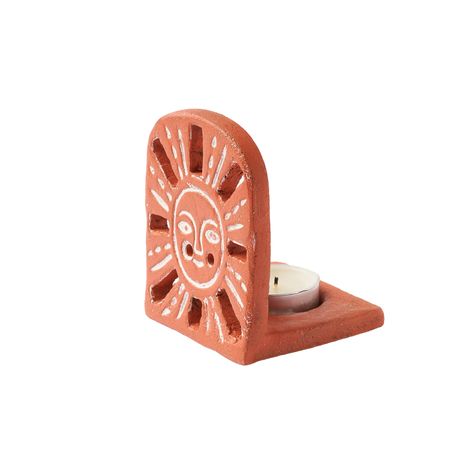 This Aayu Sunrise Terracotta Tealight Candle Holder from the Aayu Collection boasts a unique and attractive design that features silhouetted holes in the terracotta clay. The perfect gift for any special occasion, this candle holder will add a warm and cheerful ambiance to any space. Get well soon wishes and birthday surprises alike will be even more meaningful when presented in this delightful tealight holder. DETAILS Materials: Terracotta Made in India DIMENSIONS 2.5"L, 3"W, 3"H CARE Wipe clea Candle Holder Air Dry Clay, Terracotta Clay Ideas, Air Dry Clay Tealight Holder, Terracotta Clay Crafts, Clay Shelves, Clay Photo Holder, Air Dry Clay Candle Holder, Clay Luminaries, Terracota Clay