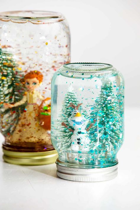 Making your own snow globe is easier than you think! Follow these simple instructions to create your own, DIY Snow Globe with the kids. #WelcometoNanas #DIYSnowGlobe #EasyCraftsforKids #SnowGlobewithGlue Lighted Snow Globes Diy, Christmas Crafts 4th Grade, Homemade Christmas Snow Globes, Diy Dollar Tree Snow Globe, Christmas Snowglobe Craft, Water Globes Diy, Home Made Snow Globes, Diy Snowglobe Ideas, Dollar Tree Snow Globes Diy