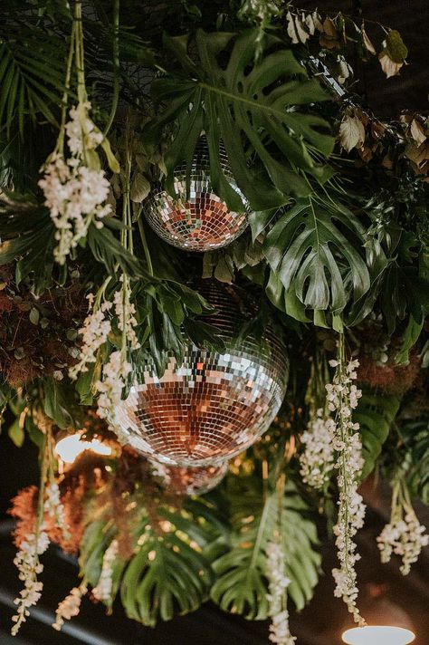 Tropical Palm Leaves with Disco Balls and Dainty White Flowers | Wedding Reception Dance Floor Installation Eclectic Tropical Wedding, Disco Ball Tropical Wedding, Disco Balls And Palm Leaves, Disco Ball Tropical, Mamma Mia Wedding Reception, Jungle Disco Wedding Decor, Disco And Greenery, Green And Disco Ball Decor, Earthy Disco Wedding