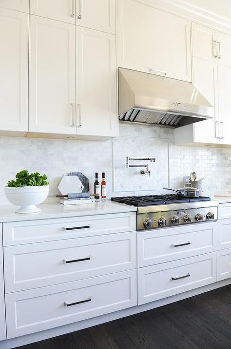 Mini brick marble backsplash graces a gorgeous white kitchen with a stainless steel upgrades, swivel pot filler, and traditional steel vent hood. Gorgeous White Kitchen, Model Dapur, Upper Kitchen Cabinets, Interior Dapur, Kabinet Dapur, Transitional Cabinets, Kitchen Cabinets Decor, Marble Backsplash, New Kitchen Cabinets