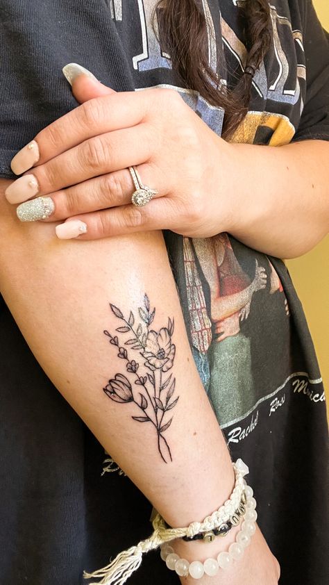 Black and gray simple wildflower tattoo on forearm Flower And Greenery Tattoo, You Belong Among The Wildflowers Tattoo, Wildflower Tattoo Forearm, Greenery Tattoo Sleeve, Greenery Tattoo, Front Thigh Tattoos, Floral Arm Tattoo, Floral Back Tattoos, Tattoo Number