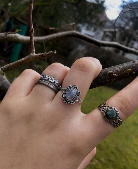 A person’s hand with multiple silver crystal rings on it. Silver Jewelry Aesthetic Rings Grunge, Earthy Rings Aesthetic, Layered Rings Silver Grunge, Crystal Rings Silver, Dark Silver Rings, Dark Fairycore Jewelry, Fairygrunge Rings, Rings Goblincore, Silver Grunge Rings