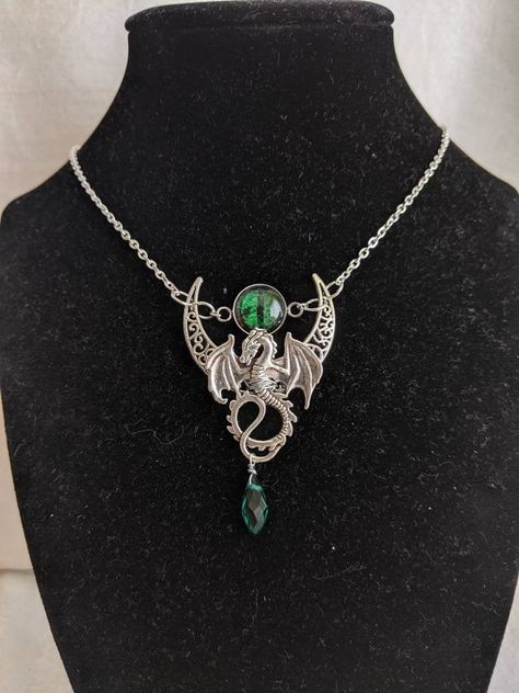 This magical necklace features a dragon on top of a crescent filigree moon, reminiscent of a dragon flying high into the moonlit sky. A matching crystal drop bead hangs from the center like dragon treasure. A mystical dragon eye sits between the crescent moon, ever seeing.  The primary color refers to the dragon eye and drop crystal color.  The secondary color refers to the chain and charm color.  The necklace length is 16 inches with a 2 inch extension chain. If you want a different length, fee Dragon Treasure, Mystical Dragon, Dragon Flying, Moonlit Sky, Eye Pendant Necklace, Mystical Jewelry, Dragon Necklace, Flying High, Dragon Jewelry