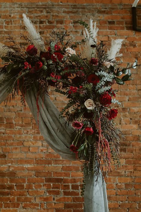 Sage Green December Wedding, Christmas Wreath Arch Wedding, Forest Green And Dark Red Wedding, Wedding Arch Ideas Christmas, Christmas Garland Wedding Arch, Forest Green And Red Wedding Theme, Sage Green Maroon Wedding, Sage Green And Red Wedding Theme, Jewel Tone Flower Arch