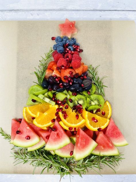 fruit platter being made in shape of Christmas tree - layer of rosemary sprigs, followed by watermelon, sliced oranges, sliced kiwis, sliced grapes, sliced strawberries, raspberries and blueberries with a star on the top cut from a slice of watermelon Christmas Fruit Snacks, Christmas Cooking Ideas, Christmas Fruit Platter, Festive Fruit Platter, Cousins Christmas, Christmas Fruit Salad, Camp Christmas, Christmas Veggie Tray, Fruit Board