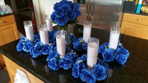 Repast centerpieces...candle rings, tall white candles royal blue roses Blue Roses Centerpieces, Royal Blue And Gold Wedding Centerpieces, Royal Blue And White Wedding Centerpieces, Royal Blue Winter Wonderland Wedding, Royal Blue Black White Silver Wedding, Royal Blue And White Centerpieces, Black White And Royal Blue Wedding Decor, Blue And White Centerpieces For Party, Royal Blue Table Decorations