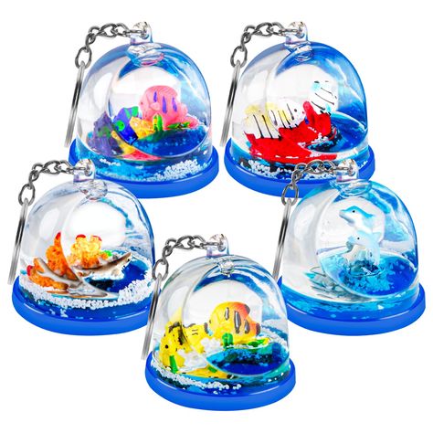 PRICES MAY VARY. Versatile Spherical Design: Uniquely crafted semi-transparent ball keychain filled with a mesmerizing underwater scene. Enchanting Miniature Ecosystem: Inside, watch the dance of a playful dolphin, vibrant red and yellow fish, stunning red coral, and the elusive white polar bear. Soothing Liquid Motion: Lose yourself in the calming flow of the contained liquid, perfect for those moments you need a touch of tranquility. High-Quality Construction: Designed for durability with leak Dolphin Party, Hourglass Design, White Polar Bear, Yellow Fish, Mini Accessories, Toy For Kids, Fidget Toy, Cute Little Things, Sensory Play