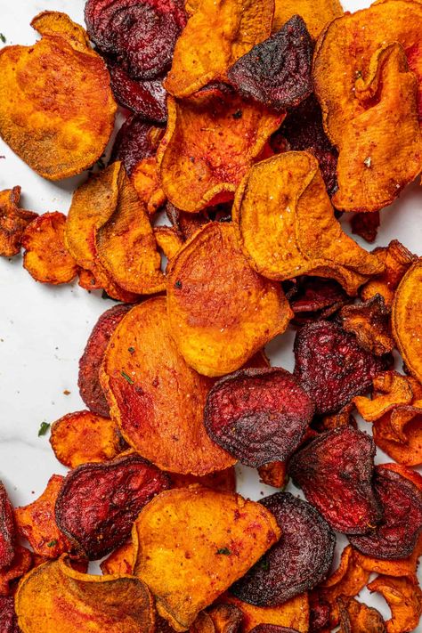 Homemade Air Fryer Veggie Chips are a great healthy snack. Beets, carrots, and sweet potatoes are used in this recipe, all of which are loaded with vitamins and minerals like vitamin A, vitamin C, potassium, and iron. And the best part is that they taste divine! After a quick coating in olive oil, the veggies are ready to be cooked in the air fryer. The result is a crispy, crunchy snack that’s absolutely addictive! It’s impossible to eat just one because they are so good! Vegetable Crisps Air Fryer, Air Fryer Veg Chips, Crisps In Air Fryer, Air Fryer Vegetable Crisps, Air Fryer Vegetable Chips, Veggie Chips Air Fryer, Air Fryer Carrot Chips, Air Fryer Crisps, Carrot Chips Air Fryer