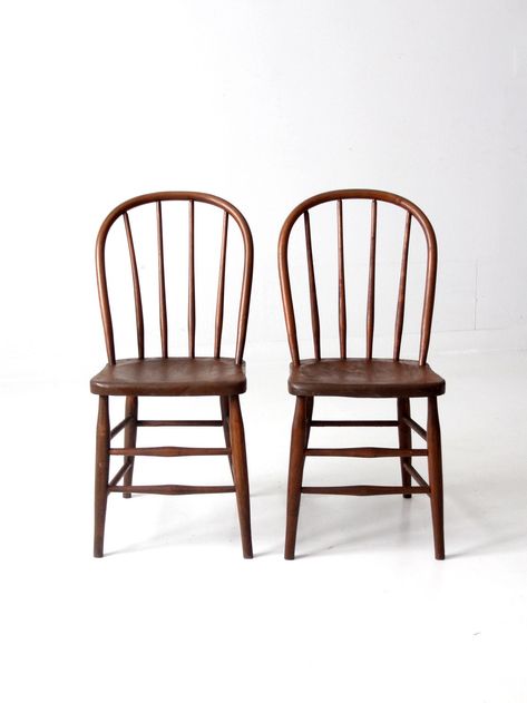 "This is a pair of vintage wood dining chairs.  The Windsor style chairs feature round spindle backs and splay legs.  Beautiful patina to the wood finish.   CONDITION In good condition with wear consistent with age and use.  MEASUREMENTS Height:  35\"  .. 88.9 cm Width:  17\" ..  43.2 cm Depth:  19.75\"  .. 50.2 cm Seat Height:  18.5\"  ..  47 cm Seat W x D:  15.5\" x 14\"  .. 39.4 cm x 35.6 cm SHIPPING Standard shipping via ground service.  Delivery estimate in 2-5 weeks. Faster shipping availa Spindle Chair Dining, Wooden Crate Boxes, Spindle Chair, Cane Back Chairs, New England Farmhouse, Windsor Chairs, Spindle Dining Chair, Wooden Dining Chairs, Bentwood Chairs