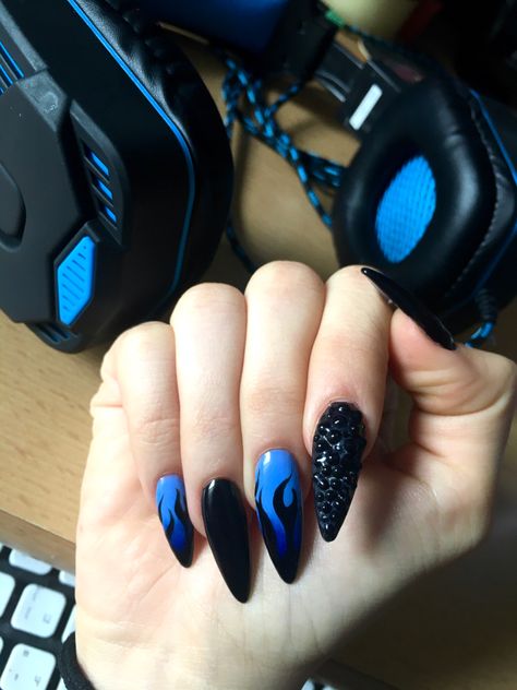 Lit black and blue nails with some gems on the index finger Black And Blue Fire Nails, Nails Inspiration Black And Blue, Black Blue Nails Ideas, Black Nails With Blue Tips, Blue And Black Flame Nails, Black And Blue Halloween Nails, Black With Blue Nails, Black And Blue Nails Acrylic Design, Blue And Black Nails Ideas