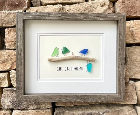 Handmade sea glass artwork featuring seaglass birds in a variety of colors sitting on a branch with the message "Dare to Be Different". Perfect inspirational gift. Don't be afraid to be yourself! Each piece is unique and I hope you find as much joy in looking upon your new piece as I took in creating it!  This artwork measures 8 x 8 unframed and includes a high quality gray wood display case frame.  While you can find all of my ready-to-ship pieces of art currently on Etsy, I would be more than Seaglass Birds On A Branch, Bird Sea Glass Art, Sea Glass Birds On A Branch, Seaglass Pictures Diy, Beach Glass Art Diy, Seaglass Art Ideas, Seaglass Cards, Seaglass Birds, Beach Glass Projects