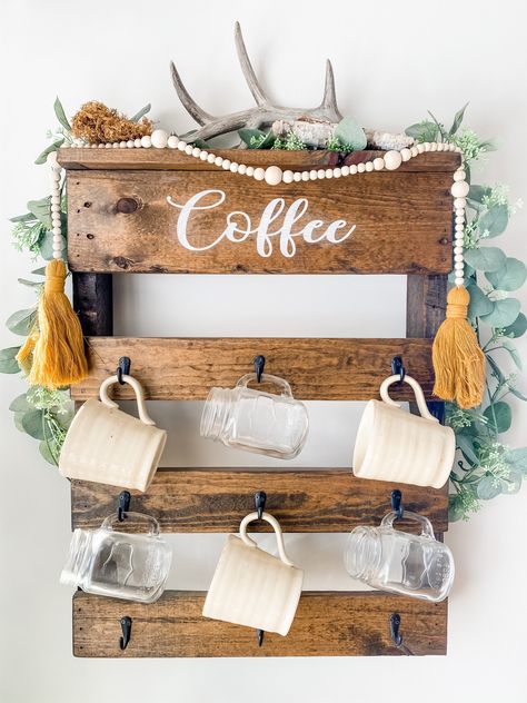 "This coffee rack is made from 100% pallet wood. It holds 9 coffee mugs. The word \"coffee\" is hand painted and designs vary. This is a great Wall conversation piece! The coffee rack is approximately 27 inches tall and  21 inches wide. Coffee rack sizes vary just a bit depending on the pallet used. Contact us with custom colors!" Coffee Rack, Wood Pallet Wine Rack, Coffee Cup Rack, Antler Projects, Painting On Pallet Wood, Blue Coffee Cups, Diy Coffee Bar, Farmhouse Coffee Bar, Rustic Mugs