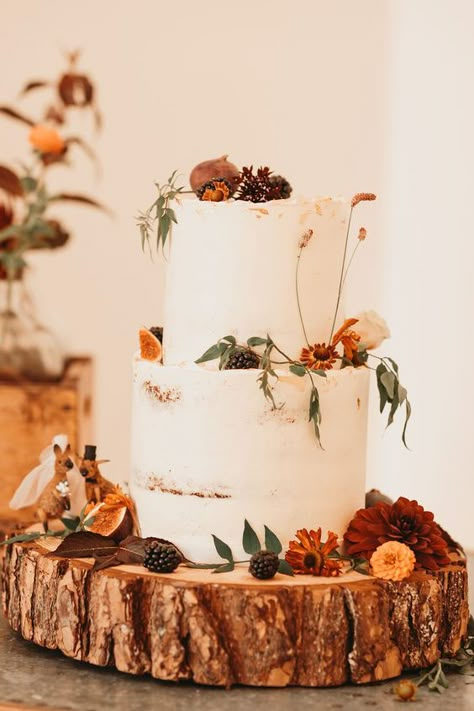 Set a serene fall day vibe with this simple two-tier wedding cake decored with figs, pine cones and wildflowers, click to learn more rustic wedding cake ideas. Fall Wedding Cakes Two Tier, Cake Table Fall Wedding, Autumnal Cake Decoration, Cake Table Wedding Rustic, White Autumn Wedding, Autumn Cake Wedding, Autumnal Flowers Wedding, September Wedding Cake Ideas, Rustic Autumn Wedding Cake