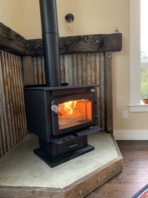 Wood Stove Tin Surround, Rustic Hearth Ideas, Rustic Wood Burning Stove, Corrugated Metal Wood Stove Surround, Shed Fireplace, Wood Stove Metal Surround, Woodstove Surrounds Metal, Corner Wood Stove Mantel Ideas, Corrugated Metal Fireplace Surround