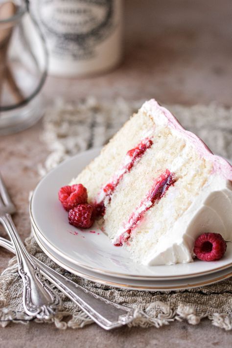 Three layers of fluffy vanilla cake with raspberry jam filling, vanilla buttercream and raspberry buttercream, in a high altitude tested recipe. Chocolate Buttercream Cake, Miniature Desserts, White Chocolate Buttercream Frosting, White Chocolate Raspberry Cake, Cake With Raspberries, High Altitude Baking, White Chocolate Buttercream, Raspberry Buttercream, White Chocolate Cake