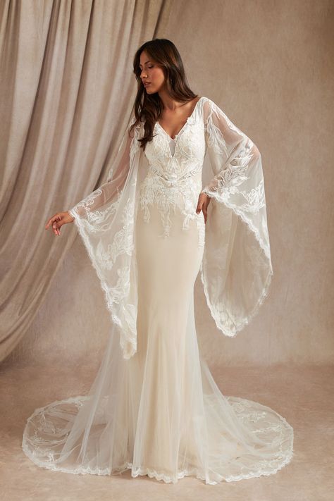 Walk down the aisle effortlessly with our tulle and lace mermaid gown, Harmonia. Her V-neckline is adorned with hand sewn lace that drapes over your shoulders and onto the illusion scoop back. Her billowy angel sleeves are trimmed with our eyelash lace. Her figure-hugging skirt extends to a chapel train that is adorned with a lace motif. Loose Lace Wedding Dress, Wedding Dress Angel Sleeves, Wedding Dress With Wing Sleeves, Bellsleeve Wedding Dress, Long Bell Sleeve Wedding Dress, Witchy White Wedding Dress, Boho Flare Sleeve Wedding Dress, Wedding Dress Dramatic Sleeves, Bell Sleeved Wedding Dress