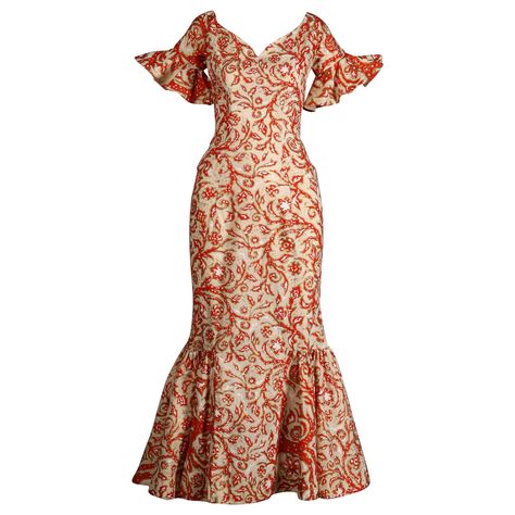 Rare 1950s Hawaiian dress made by Surf and Shore in Honolulu. Mouth watering vintage hand pulled screen printed fabric in orange, white and metallic gold. Dramatic flared bell sleeves and plunging neckline. 1950s bombshell hourglass silhouette! Unlined with rear metal zip and hook closure. The fabric content feels like cotton but is unmarked. Fits like a modern size XS. The bust measures 34", waist, 24", hips 35", and total length 52.5". The bottom hem has about 1.5"-2" that can be let out. Exce Hawaiian Dress Pattern, Puletasi Designs, Traditional Hawaiian Dress, 1950s Bombshell, Samoan Clothing, Dress Hawaiian Style, Samoan Dress, Hawaiian Muumuu, Island Style Clothing