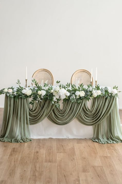 #6ftFlowerGarland Flower garlands could be used on the reception table setting/centerpiece decor, arch/arbor florals, archway laydown garland, etc. Particularly, the best ideal for low-budget Sweetheart Table/Head Table Floral Decor! REFERENCE: The table in the photo is about 6ft long and 29.5" tall. PACKAGE DETAILS: Package: Pre-Made floral garland x1. Size: 13.75" wide x 6ft long x 3.5" tall (after fluffed). Material: Handmade with silk/foam flowers and silk garland. Pure white chorale rose as Head Table Garland With Flowers, Bridal Table Greenery, Flower Petals Centerpiece, Sweetheart Table Rectangle, Bridal Party Head Table Ideas, Wedding Backdrop Fabric, Wedding Arch Behind Head Table, Long Floral Arrangement For Table, Long Reception Tables