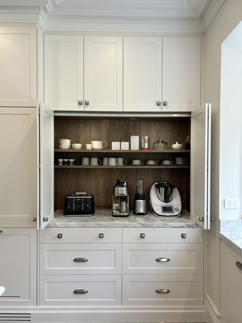 Custom designed polyurethane appliance cabinet, constructed in a timber grain Lamiwood with round LED lighting. Fitted with bi-fold opening doors and a 40mm natural stone benchtop. #kitchensbyemanuel #customjoinery #appliancecabinet #storagegoals #appliancecabinet Pantry Appliance Counter, Kitchen With Appliance Garage, Cabinets For Appliances, Kitchen Appliance Station, Coffee Garage In Kitchen, Cabinet With Appliance Garage, Kitchen Appliance Placement, Appliance Cupboard Kitchen, Appliance Cabinet Kitchen