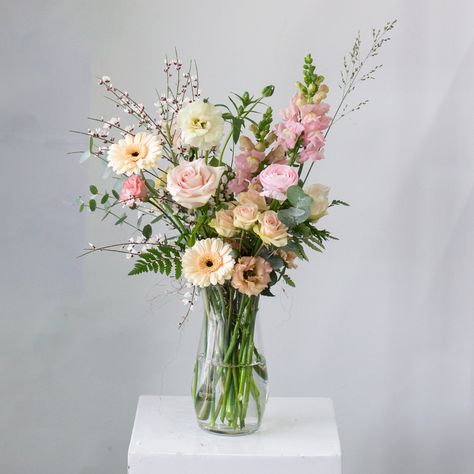 A variety of blooms and textures styled in a tall glass vase. The vase is 9" tall. The whole arrangement is approximately 18" tall and 8" in diameter. Please note: Photos are examples of size and style only. We work with a different variety of flowers each week. Your bouquet will be unique to you. We cannot replicate photos or past orders. While we encourage design notes and requests, we cannot guarantee specific flowers and/or colours. Tall Pink Flower Arrangements, Tall Narrow Vase Arrangement, Floral Arrangement In Vase, Flower Vase Bouquet, Pink Vase With Flowers, Flowers In Tall Vase, Tall Floral Arrangements For Home, Long Vase Flower Arrangements, Flower Colour Palette