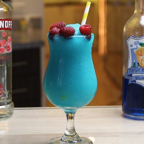 The Frozen Blue Raspberry is a little slushy, boozy dream. This stunning blue cocktail combines raspberry vodka, blue curacao, orange juice, lime juice, sour mix, and raspberries, and is guaranteed to satisfy all those raspberry mixed drink lovers out there. Blue Raspberry Drinks Alcohol, Blue Raspberry Mixed Drinks, Blue Raspberry Vodka Drinks, Blue Beverages, Boozy Slushies, Raspberry Vodka Drinks, Frozen Drinks Alcohol, Raspberry Margarita, Vodka Blue