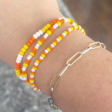 Show some Halloween spirit with these fun Candy Corn bracelets. You can't help but smile when you wear them. I made these using two different size seed beads for added texture.  Mix n match with my other bracelets for endless styles!  You will receive 3 bracelets that are made on strong stretch cord and made to fit a 7 1/2" wrist. Need a different size? Just let me know your wrist size and I will be happy to custom make for you! Each piece is handmade with: - High Quality Glass Seed Beads - Stretch Cord: High-quality cord with reinforced knots Easily layer with other Luna by Rachel bracelets for a stunning stack! My pieces are made sturdy, but as with all jewelry, they are also delicate and should be treated with care. Be sure to check out other designs in my shop at http://etsy.com/shop/l Candy Corn Seed Bead Bracelet, Small Seed Bead Bracelet, Simple Bracelets Diy Beads, Fall Stretch Bracelets, Candy Corn Bracelets, Beaded Bracelets Fall, Seed Bead Bracelet Sets, Fall Seed Bead Bracelets, Halloween Seed Bead Bracelet