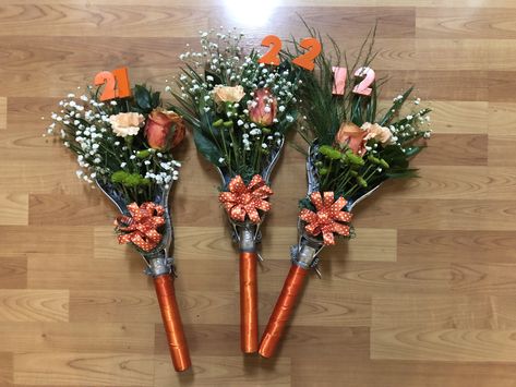 Lacrosse flower bouquet Lacrosse Wreath Front Doors, Lacrosse Team Party Ideas, Lacrosse Stick Flower Bouquet, Senior Bouquet Ideas, Basketball Flower Bouquet, Lacrosse Bouquet, Lacrosse Coach Gifts Ideas, Lacrosse Senior Gifts, Lacrosse Senior Night Gifts