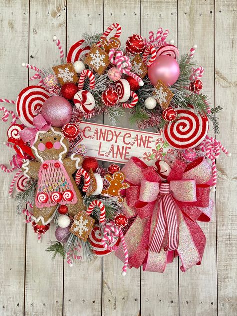 "28\" LARGE Christmas Winter Holiday Gingerbread  Candy Lane Red White and Pink wreath for your front door porch entrance entryway wall hanging home decor.    Completed wreath Measures approximately 28\"-30\"(W) x 8\"-10\"(D).  White glitter grapevine wreath frame, frosted pine greenery, Accented with Beautiful glittered multi ribbon bows red white & pink, CANDY CANE LANE MDF wood sign, Gingerbread attachment, peppermint & candy glitter sprays and ornaments, and various other Christmas candy accents.  **Indoor/Outdoor but for best longer lasting results display in a covered or protected area. Over time exposure to sun and weather may  cause some fading.... some materials more than others" Pink Door Christmas Decor, Christmas Candy Front Porch, Pink Front Door Christmas Decor, Candy Cane Theme Wreath, Teal Red Pink Christmas, Christmas Wreath Gingerbread, Pink Red Christmas Wreath, Candyland Christmas Front Porch, Pink And White Christmas Wreath