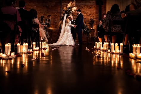 candle-lit wedding ceremony at Brick & Mortar events with backdrop made by friends and family of the couple Candlelight Wedding Ceremony Outdoors, Dim Lit Wedding Ceremony, Indoor Candlelight Wedding, Candle Lit Isle Wedding, Candle Lit Weddings, Candle Lite Wedding Ceremony, Bridesmaids Holding Candles, Candle Lit Isle, Candle Lit Wedding Reception Romantic