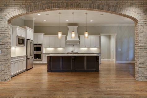 Kitchen perfectly framed by interior brick arch. Brick Opening To Kitchen, Pillars In Kitchen, Arched Kitchen Opening, Brick Arch Kitchen, Archway Into Kitchen, Kitchen With Arch Opening, Brick Arches Interior, Stone Archway Interior, Interior Brick Archway