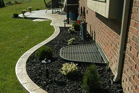 Landscaping around window well and pipes | Landscape. | Pinterest Egress Window Landscaping, Landscaping Around House, Cement Patio, Concrete Patio Designs, Egress Window, Window Well, Stamped Concrete Patio, Landscape Edging, Front Patio