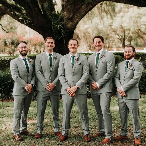 Groomsmen Fashion Inspiration 💚 Venue: @mossestatesvenue⁠ Photography: @monicagracephotography⁠ ⁠ For more Central Florida wedding inspiration follow @WhiteRabbitEventPlanning⁠ ⁠ #whiterabbiteventplanning⁠ #orlandoweddingvenues #barnweddingvenue #weddingphotographer #loveisinthedetails #groomfashioninspiration #groomsmenfashion #boutonniere #dayweddings Light Grey Suit Green Tie Wedding, Grey Green Suit Men, Sage Green Tuxedo Wedding Groomsmen, Gray Suits For Men Wedding Green Tie, Grey Green Tuxedo Wedding, Sage Green And Grey Groomsmen, Grey And Green Suit Men, Groomsmen Grey Suit Green Tie, Groomsmen With Green Ties