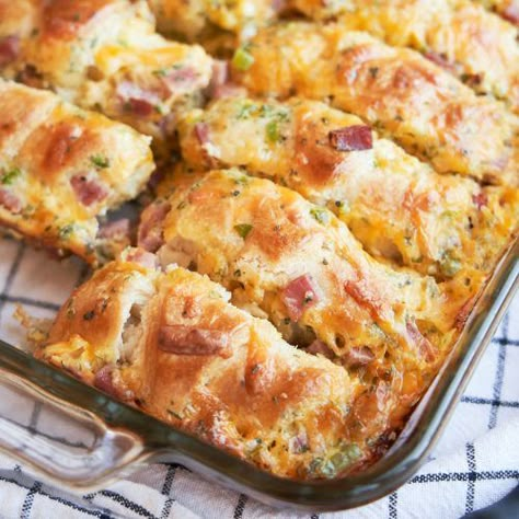 We love this crescent roll breakfast casserole! Made with 2 cans of crescent roll, ham, cream cheese, jalepeno, and egg, you will love this too! It's a big breakfast casserole that will feed plenty. Easy to make and has the WOW factor. Get the recipe on www.theworktop.com Cresent Roll Breakfast Bake, Quick And Easy Dinner Recipes For A Crowd, Easy Recipe For Large Groups, Egg Wich Recipe, Hand Held Food Meals, Fun Weekend Breakfast Ideas, Breakfast Handhelds, Easy Potluck Breakfast Ideas, Company Breakfast Ideas