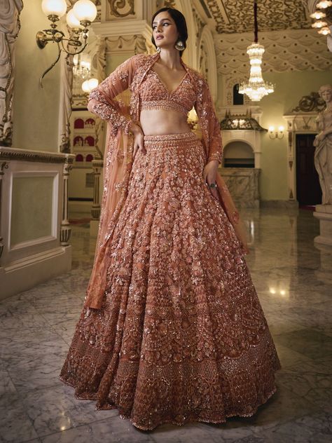 Experience elegance and grace with the Disha Lehenga. Encrusted with elaborate mirrors, pearls, and stone embellishments, this ethereal lehenga embodies opulence, perfect for any special event. The exquisite and regal design by renowned designer Seema Gujral adds a touch of royalty to your fashion statement, illuminating you as the shining star of any gathering. Majestic floral patterns, lavish attire. Key Features: Precious mirror, pearl, and stone embroidery work Pastel Peach color exuding bea Haldi Suit, Dresses For Indian Wedding, Ejaaz Couture, Sangeet Dresses, Mehndi Dress For Bride, Indian Sangeet, Indian Wedding Guest Dress, Indian Wedding Aesthetic, Lehenga Inspiration