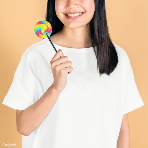 Happy woman in a white tee mockup holding a rainbow lollipop | free image by rawpixel.com / Jira Holding Lolipop Poses, Hand Holding Lollipop Drawing, Holding Lolipop Drawings, Holding Ice Cream Reference Drawing, Holding Food Reference, Hand Holding A Lollipop, Holding Lollipop Reference, Oc Development, Candy Advertisement