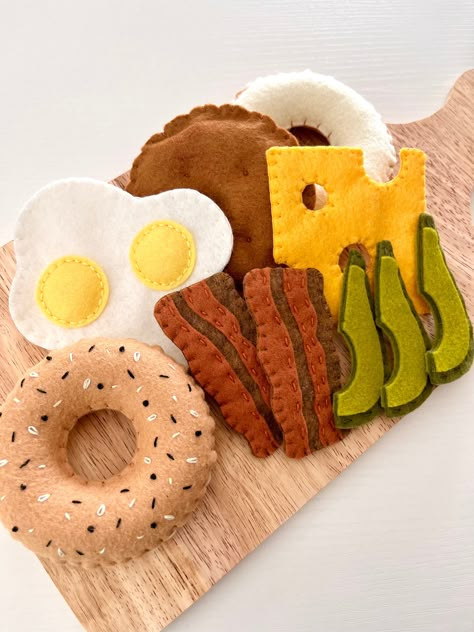 My kids love anything to do with food, especially breakfast! With this felt breakfast bagel set, there are so many different combinations to be created. Everything I create is hand sewn with a wool blend felt and some items stuffed with polyfil.  Dimmensions: Bagel: 3.75 x 3.75 Inches Sausage Patty: 3.75 x 3.75 Inches Eggs: 4.5x 4.5 Inches Cheese Slice: 3.5 x 3.5 Inches Bacon Slices : 3.5 x 1.5 Inches Avocado Slices: 3.5 x 1.25 Inches Kids Christmas Gifts Diy, Play Bakery, Felt Toys Diy, Felt Food Diy, Felt Food Patterns, Felt Kids, Play Kitchen Accessories, Felt Toys Patterns, Food Play