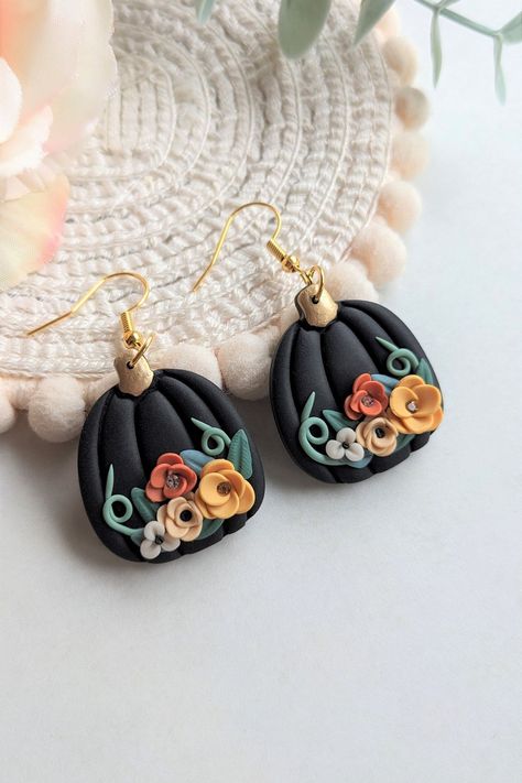 Black autumn/fall pumpkin earrings. Adorned with flowers, leaves, and vines.  Two of the flowers have rhinestones at the center to add that little touch of sparkle to your autumn outfit. They are made from polymer clay so are lightweight and easy to wear all day.  There are two styles, one with 5 flowers at the top and the other with 4 flowers at the bottom and a golden stalk.  They come with a fishhook ear wire but this can be changed to a ball stud if you prefer, both gold in color and made ou Autumn Earrings, Gothic Floral, How To Clean Earrings, How To Make Clay, Pumpkin Earrings, Clay Jewelry Diy, Fall Earrings, Fall Jewelry, Flowers Leaves