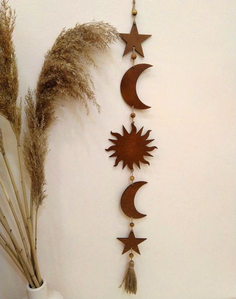 Sun, moon and stars garland is so cute decor for boho wall. This wooden boho wall hanging is a stunning decoration for your boho space! We made it in gold, brown and other natural colours. This celestial wall hanging is also decorated with wooden beads. ➤ SIZE: width 4.7 inches (12 cm) height 32.7 inches (83 cm) Witchcore Decorations, Wall Hanging Wooden Decor, Sun And Moon Wall Hanging, Sun Hanging Decor, Sun Moon Wall Decor, Moon Phase Wall Decor, Moon Aesthetic Decor, Star Home Decor, Celestial Office Aesthetic