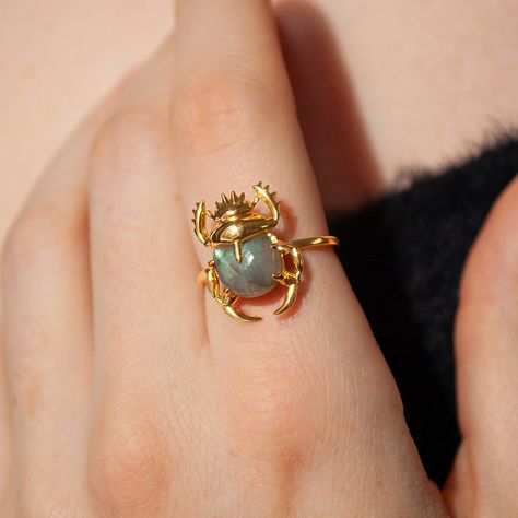 This beautiful ring is made in Sterling Silver and coated with a thick layer of 24K Yellow Gold to a Gold Vermeil thickness and set with a natural Labradorite. 24K Gold Vermeil jewelry is not only hypoallergenic, but it also does not tarnish.  Your ring is meticulously handcrafted and hand-polished to perfection. It is made to last a lifetime with proper care. This is a unique piece of minimalist jewelry for everyday wear.  Please note: Due to the one-of-a-kind nature of the gemstone, exact colors and patterns may vary slightly from the image shown. PLEASE REVIEW THESE INSTRUCTIONS TO LEARN ABOUT HOW TO PROPERLY CARE FOR YOUR JEWELRY.  To properly store your jewelry, store your jewelry in the jewelry bag, and place the jewelry bag in your jewelry box. Doing so will protect and improve the Crystal Rings Gold, Moon Face Ring, Metal Rings Handmade, Layering Rings, Nature Accessories, Scarab Ring, Yellow Gemstone Ring, Gold And Silver Ring, Wearable Art Jewelry