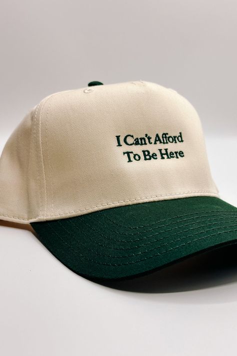 Introducing the I Can't Afford To Be Here" Trucker Hat, a witty and lighthearted accessory for your everyday adventures. This hat features a beige body adorned with bold dark green embroidery that humorously declares "I Can't Afford To Be Here." The dark green bill adds a contrasting touch, while the adjustable back ensures a comfortable fit. On the back of the hat, you'll find the embroidered phrase "The Happiest :)" to add a touch of whimsy. Perfect for those who appreciate humor and want to a Simple Trucker Hat, Trucker Hat Style, Embroidered Trucker Hats, Trucker Hat Designs Ideas, Trucker Hat Ideas, Dark Green Embroidery, Trucker Hat Designs, Trendy Trucker Hats, Trendy Hats