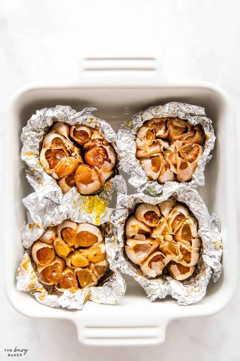 This Roasted Garlic recipe is the ultimate guide to roasting garlic so it turns out perfectly creamy and golden brown, every single time. Learn how to roast garlic in the oven and in the air fryer, and use it in all your favourite recipes! Recipe from thebusybaker.ca! #roastgarlic #howtoroastgarlic #roastedgarlic #roastedgarlicrecipe #howtomakeroastedgarlic