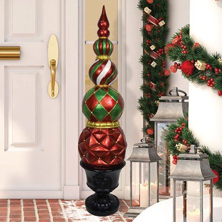 Add a designer touch to your Christmas decor with our Ball and Finial Topiary in a Pedestal Urn. Standing 4-feet tall, this festive harlequin and stripe decoration is made of durable weather-resistant resin and can be used indoors or outdoors. Display on your porch, in your foyer, or next to your fireplace to create a holiday display everyone will love. Buy two to flank a large door or a wide stairway. Your imagination is the only limit! For whimsical fun this Christmas season, count on quality Topiary Christmas Tree, Classy Christmas Porch Decor, Upscale Christmas Decor, Christmas Ball Topiary, Cardinal Christmas Decor, Ornament Topiary, Christmas Ball Decorations, Ornament Trees, Christmas Garland On Stairs