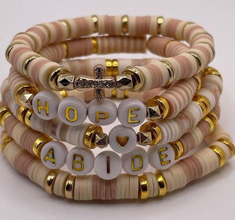 Create a stack of bracelets in a beautiful neutral rose gold like tone and cream in these personalized stretchy bracelets. One coordinating seed bead bracelet will be included with each word Clay Heshi bead bracelet. If you would like to change the words, please indicate that in the personalization section. If you need a different size, please indicate that in the personalization section. Cute Neutral Clay Bead Bracelets, Clay Bead Bracelet Ideas, Neutral Bracelets, Clay Bracelets, Neutral Color Palette, Clay Bracelet, Seed Bead Bracelet, Confirmation Gifts, Bracelet Design