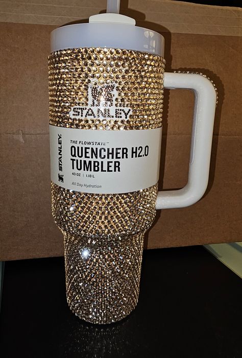 Beautiful Bling Golden 30oz Stanley Rhinestoned with Brown Logo / Covered the silver top rim with gold rhinestones along with the rubber piece on the handle / I can make this into my Crystal Stanley with the same beadwork on the handle and silver rim if you don't like gold / can take me up to 5 weeks to make and mail (depends on how many orders I have at the time) Bling Stanley Cup, Decorated Stanley, Cute Stanley’s, Bedazzled Stanley, Bedazzled Things, Alcohol Bottle Decorations, Bedazzled Liquor Bottles, Bedazzled Bottle, Gem Tattoo