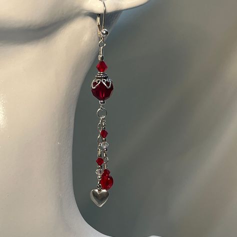 "\"FLIRTATION\" These sleek dangles have a Victorian Flare. Beautiful Deep Red Faceted Swarovski Bead with a cap of Hearts circling the crown. Hearts of red and silver dangle flirtatiously below. All being held by a Lever Back Earring. The little red heart is Czech glass, Crystals are Swarovski, and the metal is Sterling Silver. Dangle 1.25\"" Red Silver Earrings, Silver Red Jewelry, Red And White Jewelry, Red Dangling Earrings, Red And Silver Earrings, Red And Silver Jewelry, Gothic Items, Fire Accessories, Red Earrings Dangle