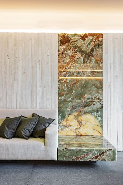 At the other end of the living-room sofa, backlighting turns a panel of Pakistani onyx into a glowing artwork. Concrete Island, Concrete Formwork, Bathroom Niche, Board Formed Concrete, 2023 Picture, Custom Wine Cellars, Vintage Floor Lamp, Black Side Table, Custom Sofa