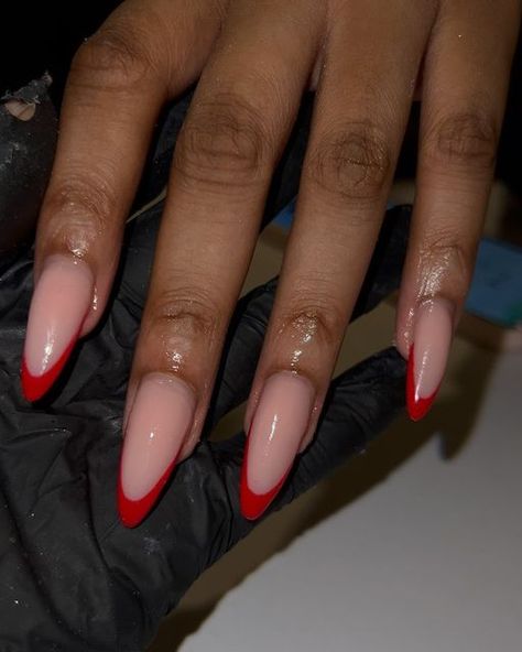 Gel Polish Almond Nails, Almond Nails With Red Tips, Red French Tip Nails Black Women, Almond Shaped Red French Tip Nails, Red Nails French Tip Almond, Nude Nails With Red Design, Red Almond Nails French Tip, Almond Nails On Black Women, Sharp Almond Acrylic Nails