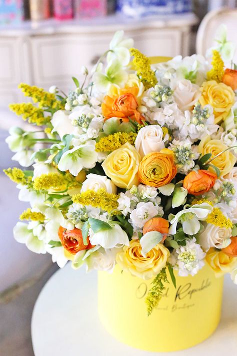 Like a ray of sunshine on a beautiful morning, this breathtaking floral arrangement showcases charming blooms in the most cheerful colors. Yellow roses and goldenrods send happy thoughts. Stocks and hellebores look refreshingly radiant in creamy white with hints of apple green. Orange ranunculus commands attention with its eye-popping hue. A fitting gift for birthdays, celebrations, or when someone needs a bit of cheering up, this beautiful creation is presented in a signature yellow hatbox. Fea Thank You Flowers Arrangement, Yellow And White Flower Arrangements, Orange Floral Centerpieces, Yellow Flowers Decoration, Yellow Floral Arrangements, Fake Flower Arrangements Diy, Yellow Flower Bouquet, Yellow Flowers Bouquet, White Hydrangea Wedding