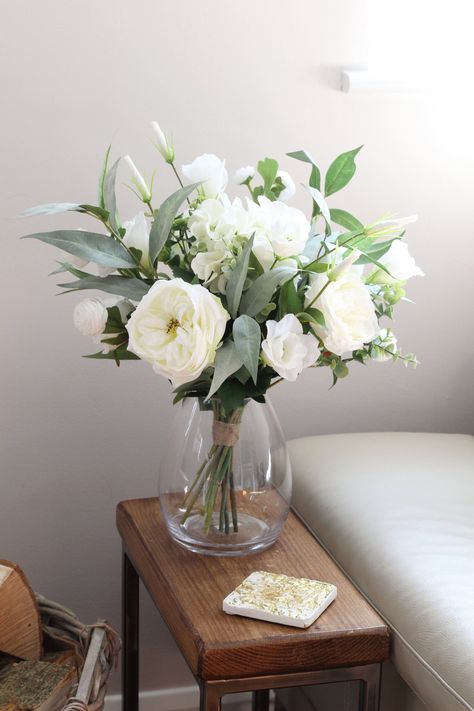 Purity white, ivory faux floral vase arrangement.  Perfect floral arrangement to brighten up your home, event or business. This arrangement includes high quality hydrangea, lissi, roses, peony and a mixed of eucalyptus finished in a lovely squat deluxe belly vase. Option to buy without vase.  Flowers are subject to availability at time of purchase.  Size of vase: 175D × 190mmH Choice to buy with or without vase. Overall size Height 45cm Widest part of arrangement 35cm across. Flower In Vase Decor, Rose Vase Arrangement, Flowers Vase Ideas, White Rose Vase, Fake Flowers In Vase, Comfort Home Decor, Floral Vase Arrangements, Bud Vases Arrangements, Flowers At Home